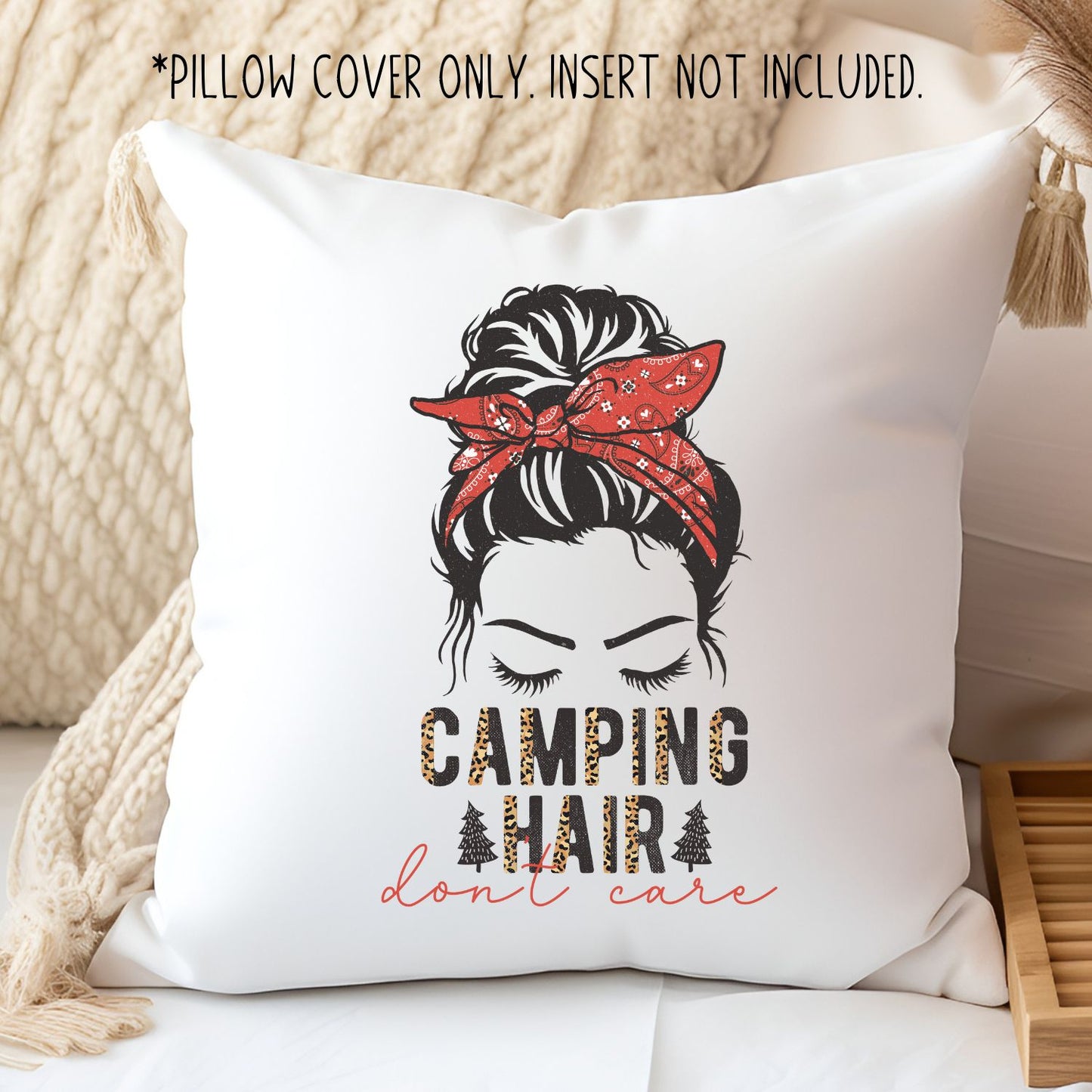 white pillow on a sofa. it has a girl with a messy bun and bandana on her head. it says CAMPING HAIR don't care". with leopard print christmas trees.