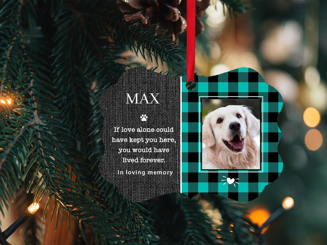 Teal plaid ornament with pet image on it and name. It says if love alone could have kept you here you would have lived forever with a little paw print. And it said in loving memory at the bottom.