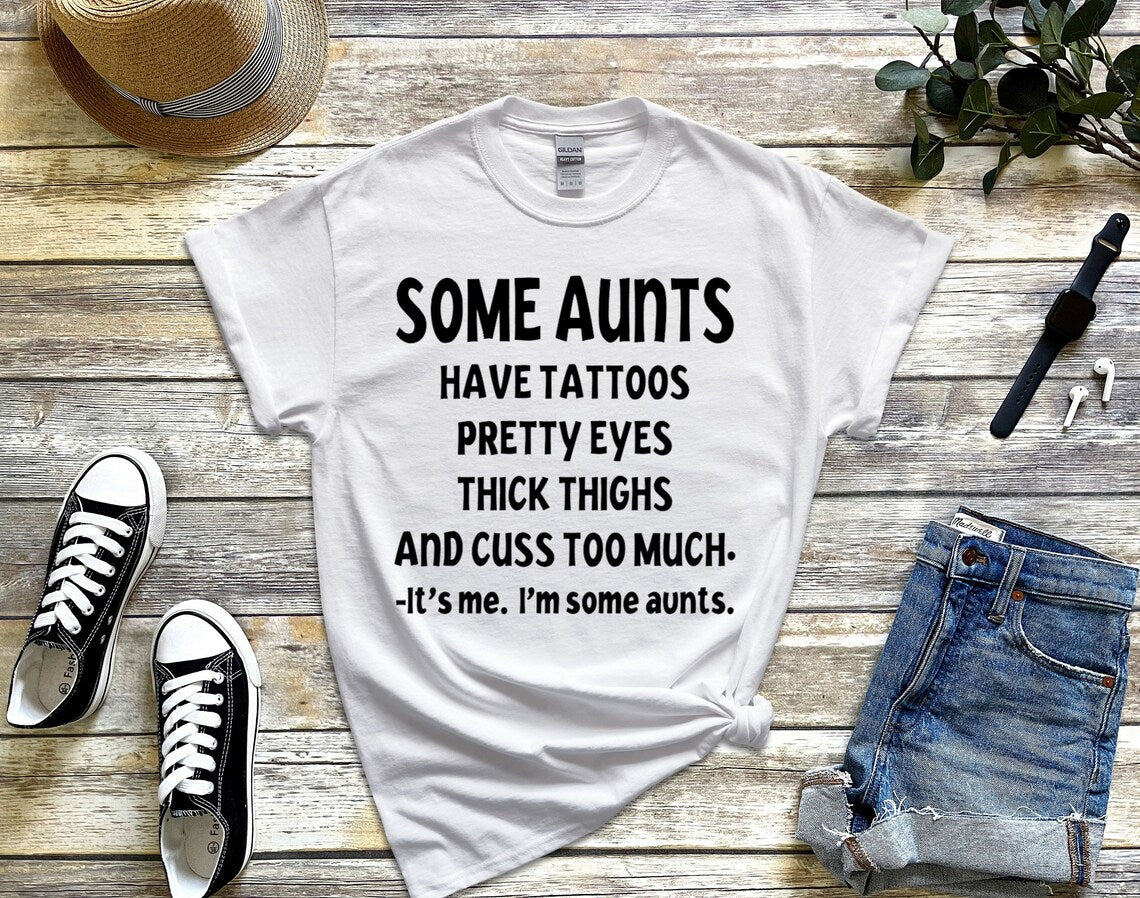 Some aunts have tattoos, pretty eyes, thick thighs and cuss too much. It's me, I'm some aunts unisex t-shirt - Designs by Tangsley
