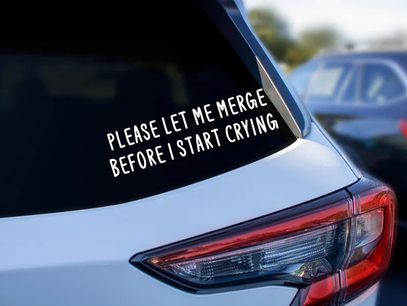 Funny white vinyl car decal that reads 'Please let me merge before I start crying' on a tinted car window – handmade in Canada