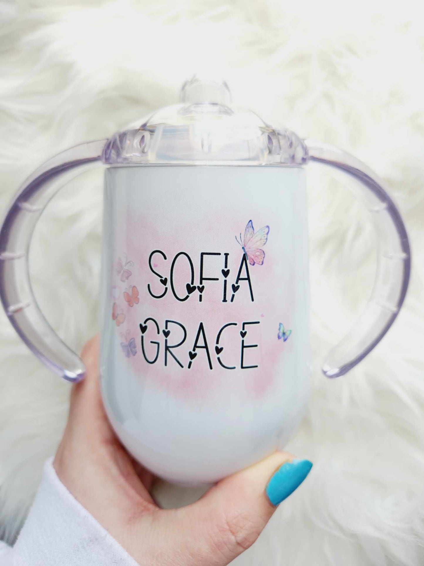 White sippy cup with child's first and middle name surrounded by purple and pink butterflies