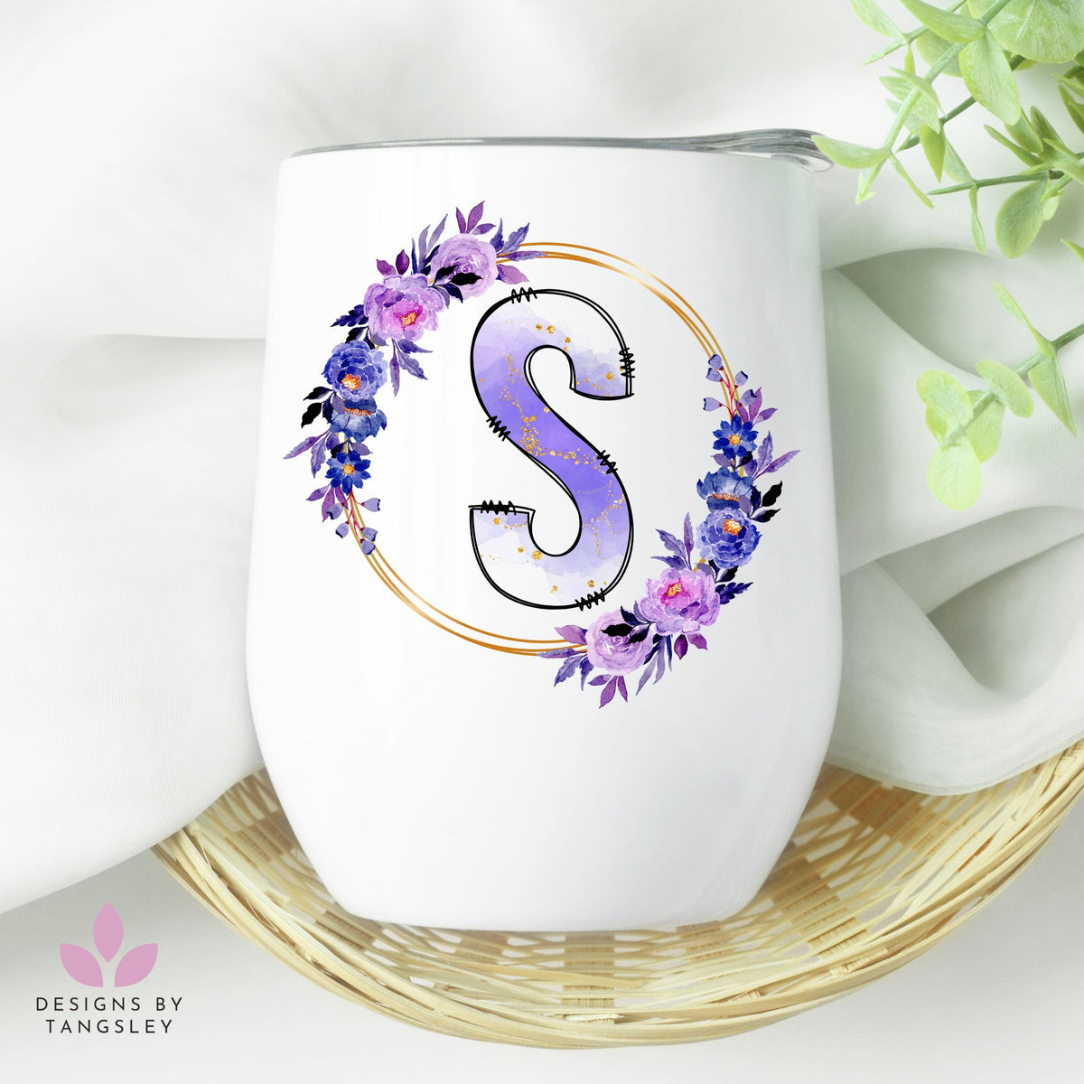 White wine glass tumbler with the letter S in a wreath of gold and purple florals.