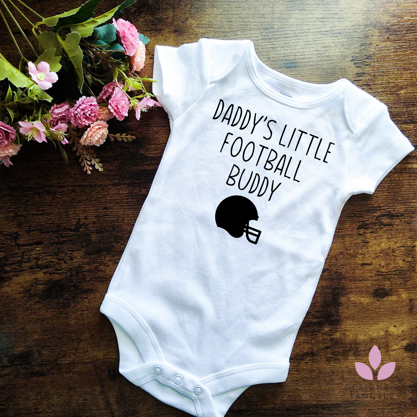 Shortsleeve white bodysuit that says DADDYS LITTLE FOOTBALL BUDDY with an image of a football helmet below it.