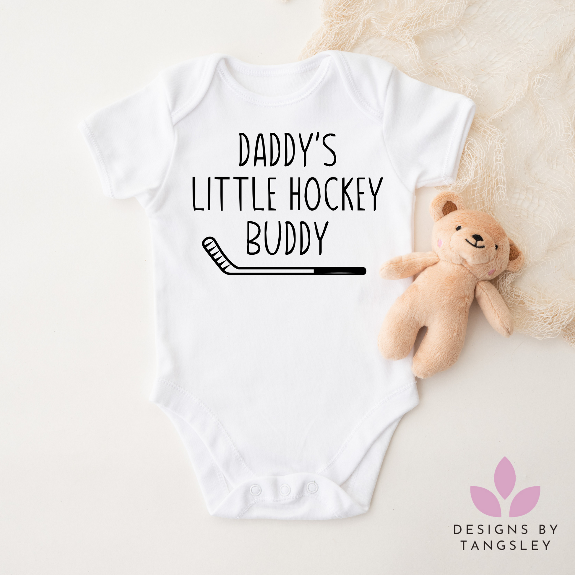 white baby bodysuit that says "DADDY'S LITTLE HOCKEY BUDDY" with a picture of a hockey stick below it.