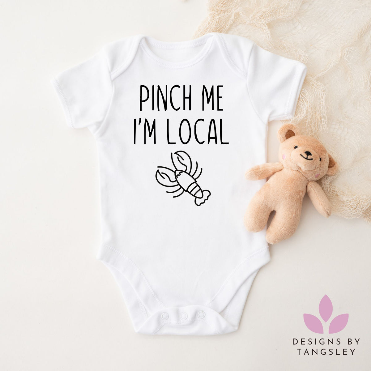 White baby bodysuit with lobster design and ‘Pinch Me I’m Local’ text – handmade gift from Cape Breton, Nova Scotia