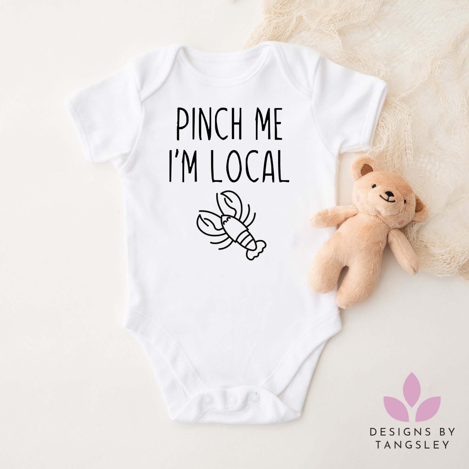 White baby bodysuit with lobster design and ‘Pinch Me I’m Local’ text – handmade gift from Cape Breton, Nova Scotia