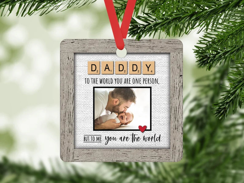 Square MDF ornament that has a "framed" design. It says "DADDY to the world you are one person but to me you are the world." looks like a scrabble piece and you add your image.