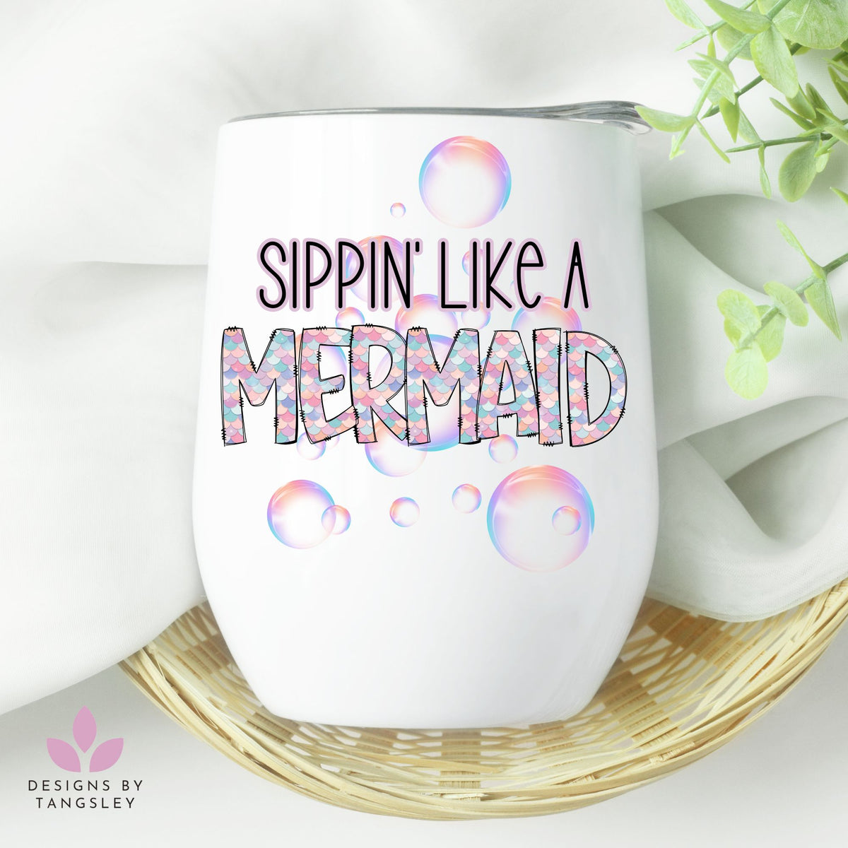 White wine tumbler with lid that says SIPPIN' LIKE A MERMAID. There's pink and purple scales and bubbles.