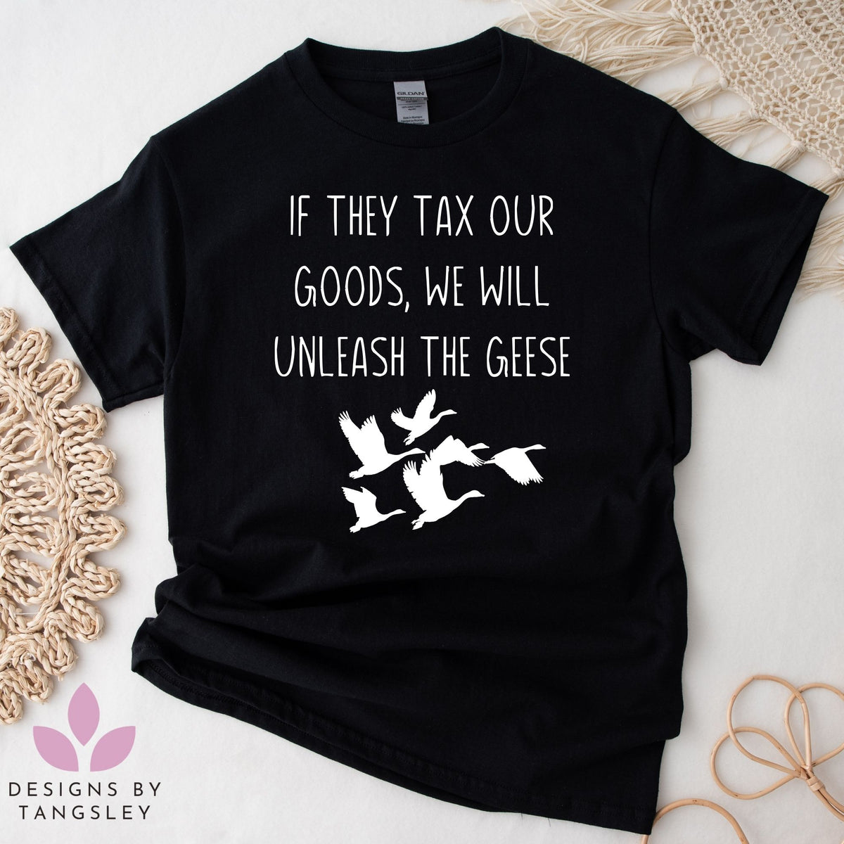 Black tshirt that says IF THEY TAX OUR GOODS, WE WILL UNLEASH THE GEESE with an image of a group of geese flying below it. The design is in white.