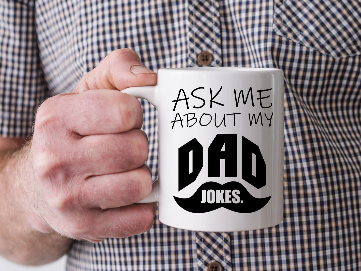 white mug, with black font and a mustache. it says "ask me about my dad jokes"