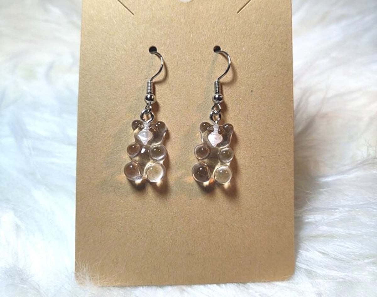 An earring card with dangle bear earrings. Silver metal components and the bears are transparent clear in color.