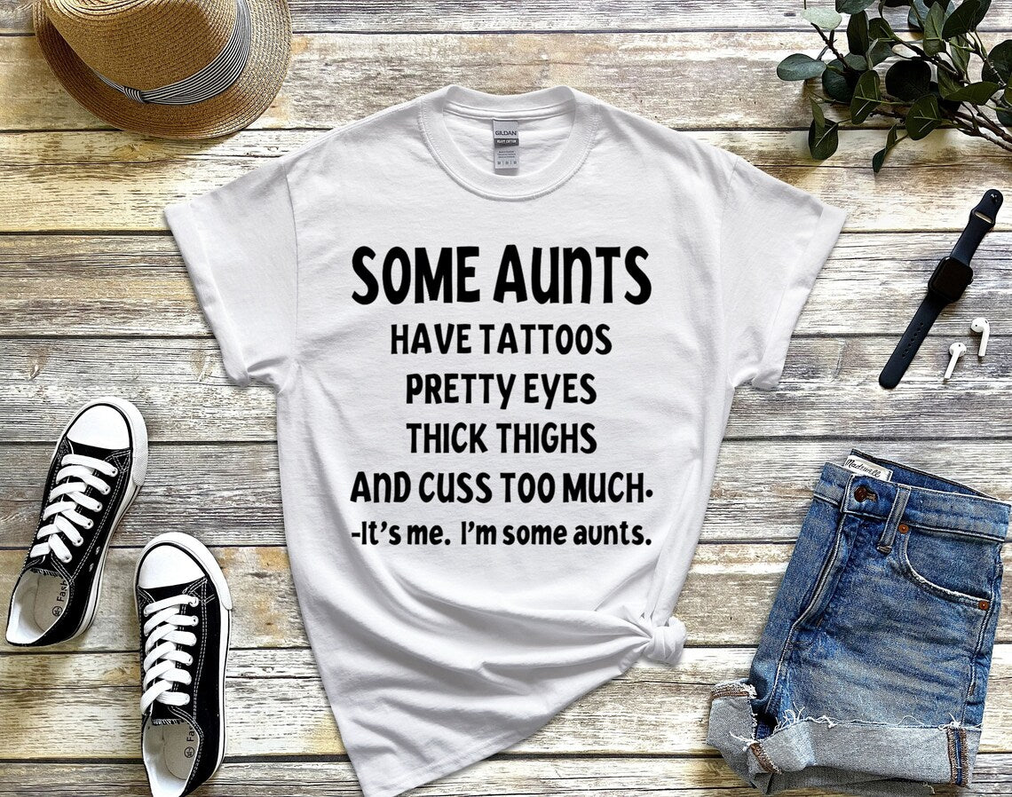 Some aunts have tattoos, pretty eyes, thick thighs and cuss too much. It's me, I'm some aunts unisex t-shirt