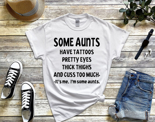 Some aunts have tattoos, pretty eyes, thick thighs and cuss too much. It's me, I'm some aunts unisex t-shirt
