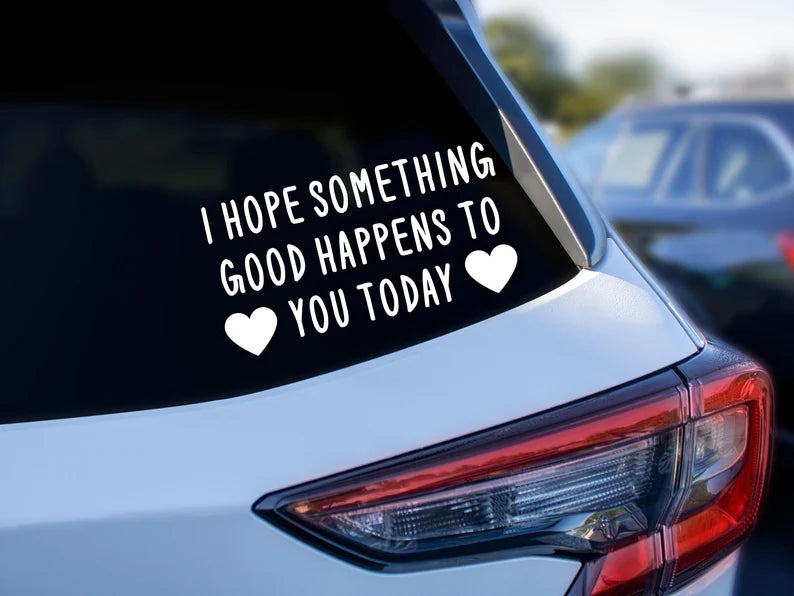 The back of a car. On the window it says "I HOPE SOMETHING GOOD HAPPENS TO YOU TODAY". with two hearts around "you today".